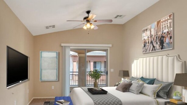 A bedroom with a bed, a ceiling fan, a TV, and a door leading to a balcony. - Perfect 2-bedroom townhome with AC in quaint Chandler (Chandler)