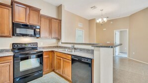 A kitchen with wooden cabinets, a built-in microwave, a stove, and a dishwasher. - Perfect 2-bedroom townhome with AC in quaint Chandler (Chandler)