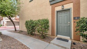 A building with a green door, a small hedge, and a sidewalk leading to the entrance. - Perfect 2-bedroom townhome with AC in quaint Chandler (Chandler)