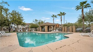 A swimming pool with lounge chairs, palm trees, and a covered pavilion. - Perfect 2-bedroom townhome with AC in quaint Chandler (Chandler)
