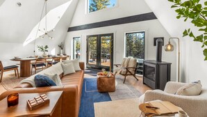 A spacious loft with a high ceiling, a dining area, a cozy seating area, and a fireplace. - Sauna, Hot Tub, Theater, A Frame near Breckenridge (Fairplay)