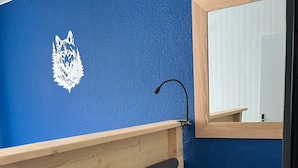 A bathroom with a blue wall, wooden vanity, a mirror, a towel, and a basket. - 8/10 people at the foot of the slopes La Plagne Centre (La Plagne Tarentaise)