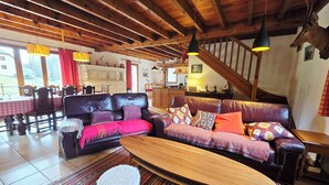 Un salon chaleureux avec un canapé en cuir, une table basse en bois et un tapis à motifs.