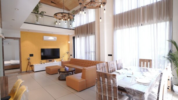 A modern living room with a sofa, coffee table, and dining table set up. - Escape to Amber Moon – Private Luxury Villa in Kumarhatti (Dharampur)