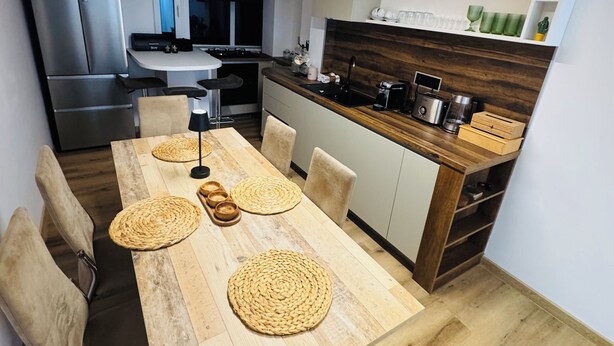 Una cocina moderna con una mesa de comedor de madera, sillas y un horno empotrado.
