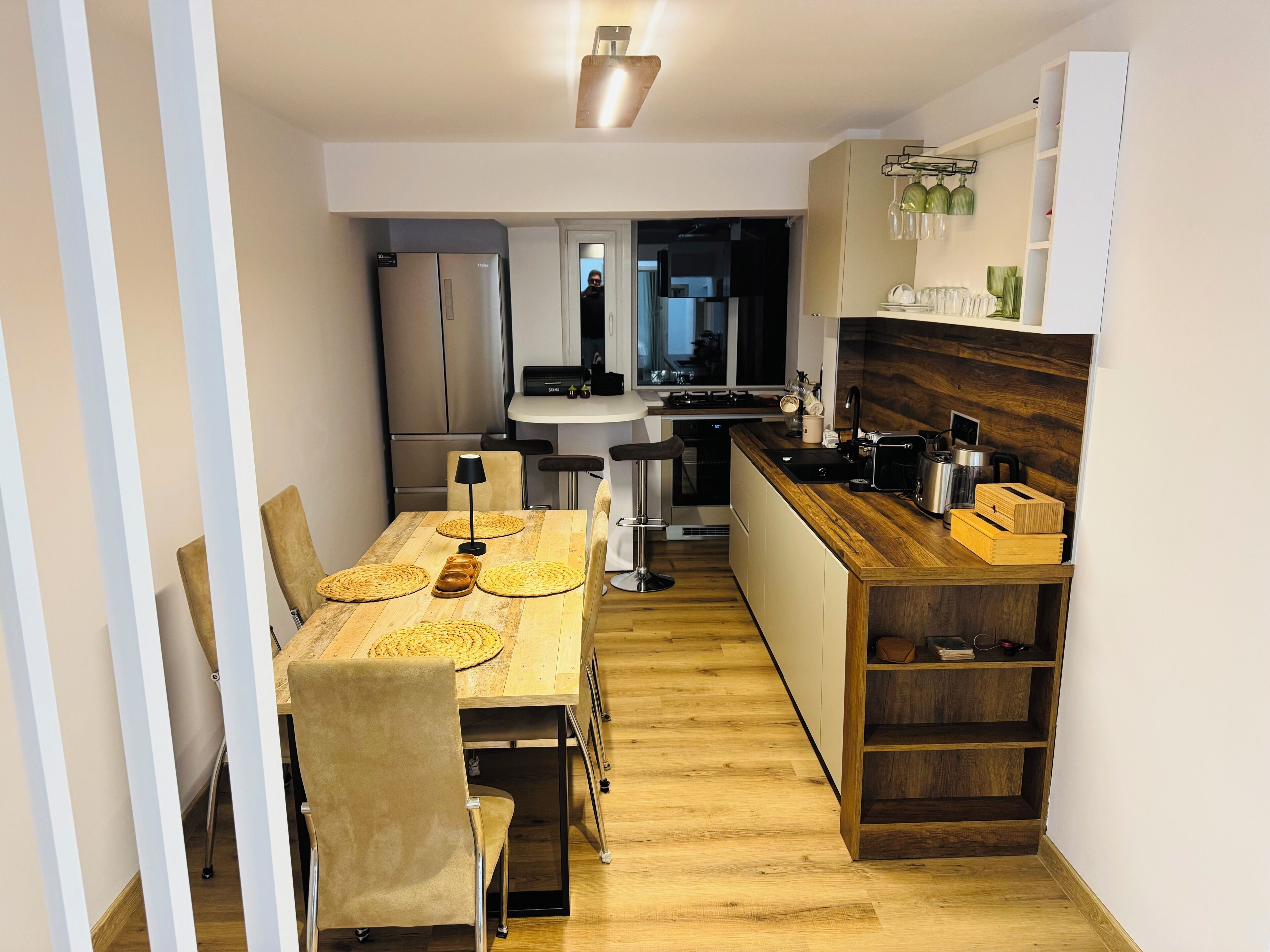 Una cocina moderna con una mesa de comedor de madera, sillas y una isla integrada con pileta y cocina.