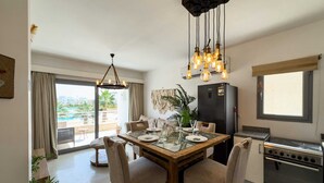 A modern kitchen with a dining table, chairs, a refrigerator, and an oven. - Genial 2bdr @ Swan Lake El Gouna (El Gouna)