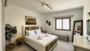 A modern bedroom with a large bed, a bedside table, a small stool, a radiator, a window, and a mirror. - Genial 2bdr @ Swan Lake El Gouna (El Gouna)