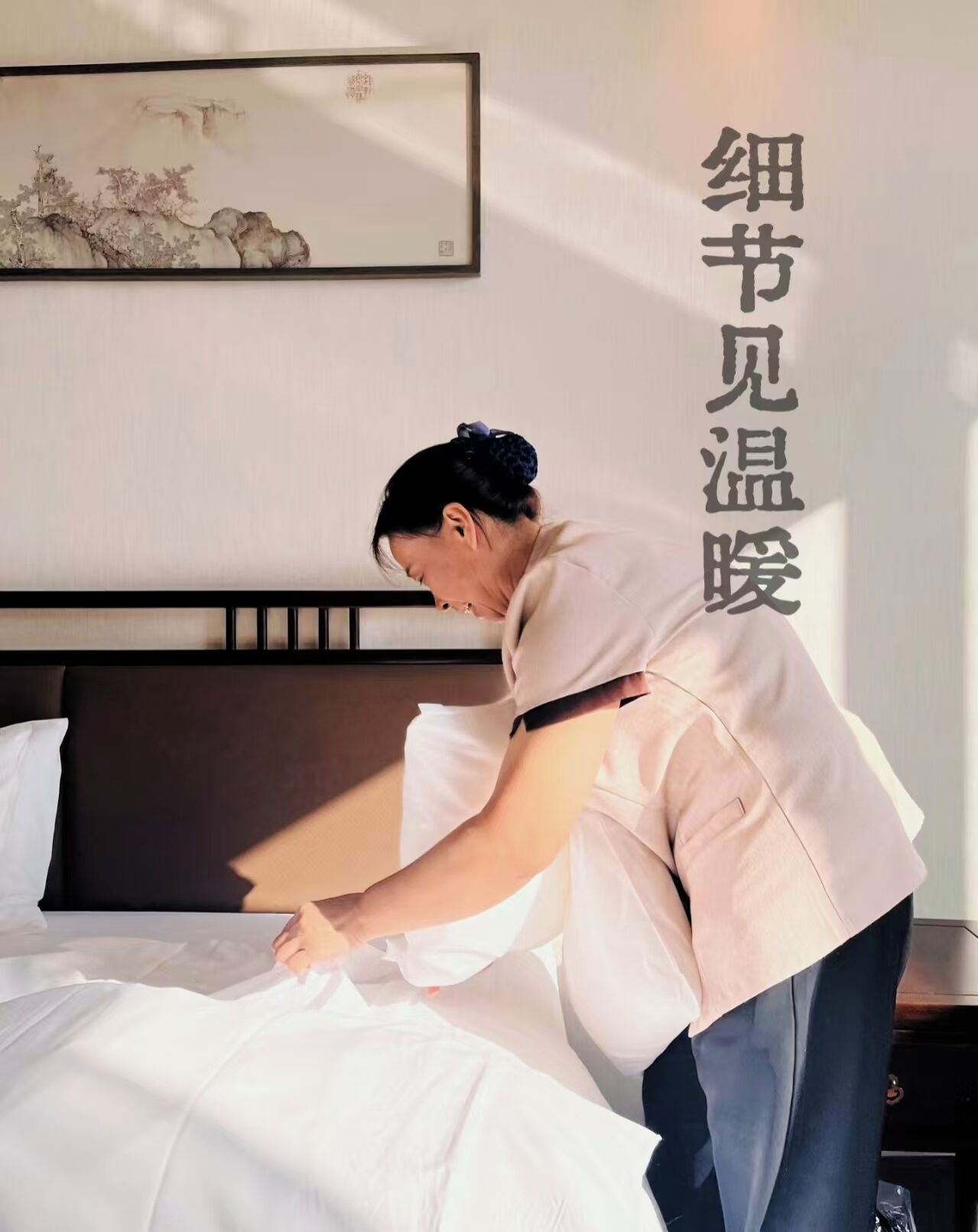 A person adjusting a bed in a hotel room.