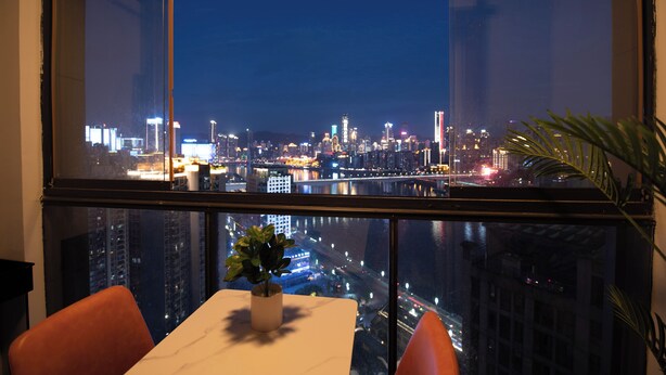 A high-rise room with a city view, a dining table, and two chairs. - Deer's Return - Riverside Summer Homestay - Beibin Road (Chongqing)
