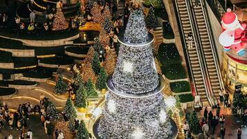 A large, multi-tiered Christmas tree structure surrounded by people.