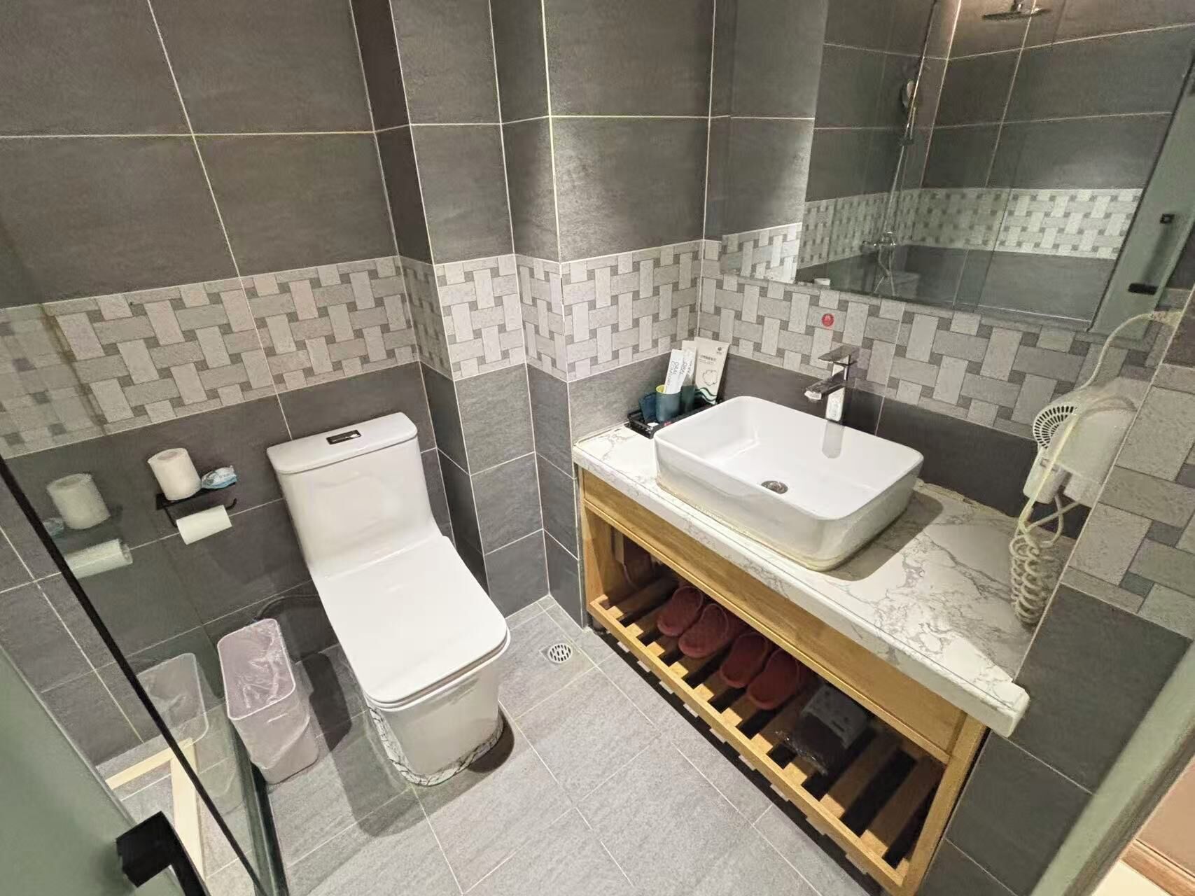 A bathroom with a white toilet, a sink, and a mirror.