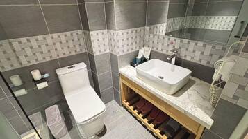 A bathroom with a white toilet, a sink, and a mirror.