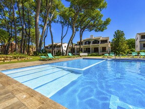 A swimming pool with lounge chairs, surrounded by trees and buildings. - Country Club Family by Interhome (Pals)