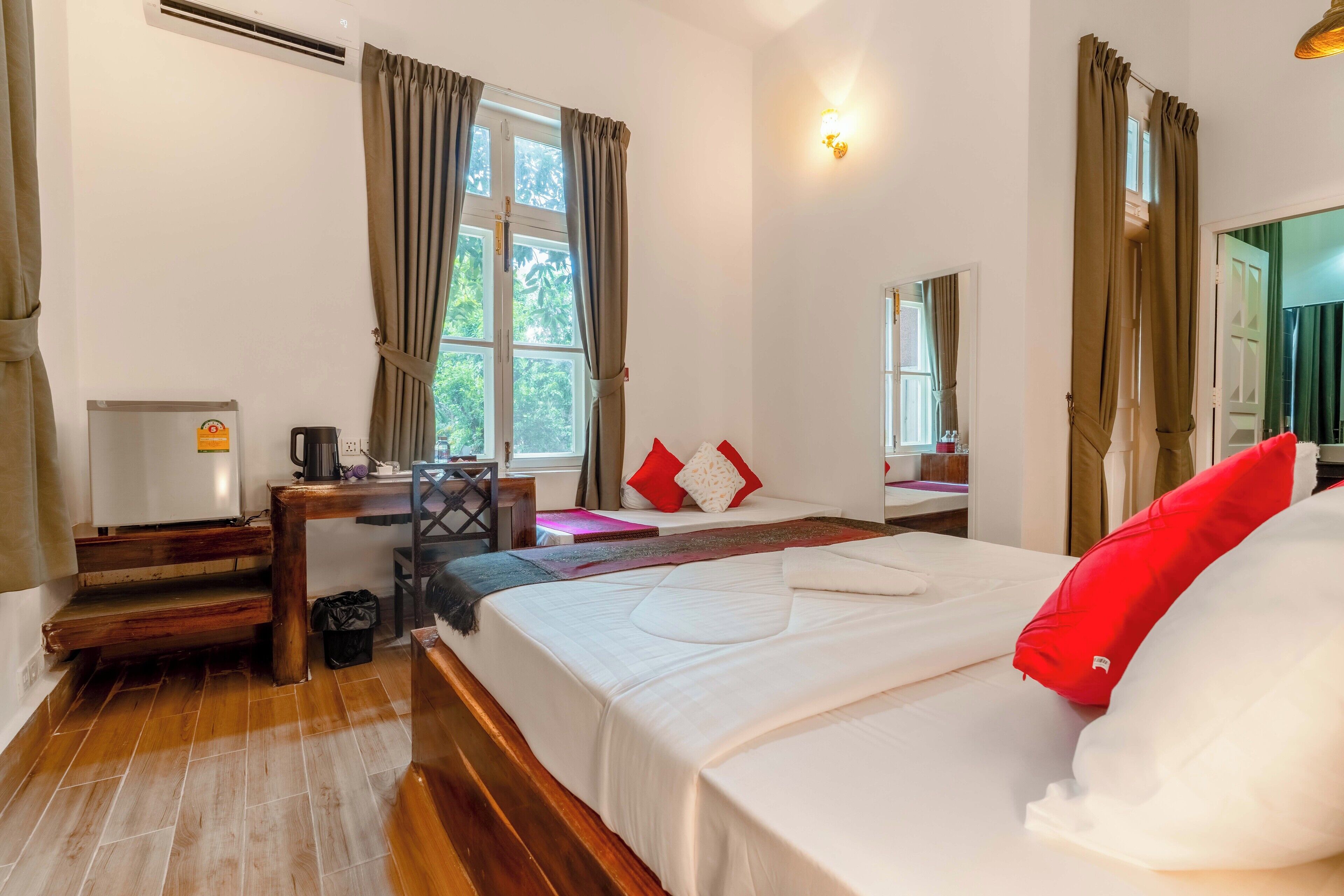 Une chambre d’hôtel équipée d’un lit, d’un bureau, d’une chaise, d’une machine à café et d’une fenêtre avec des rideaux.