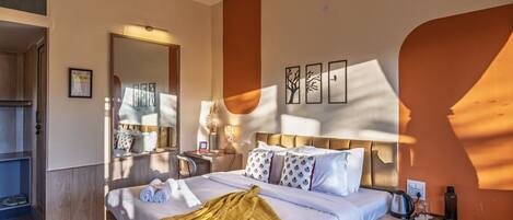 A hotel room with a bed, bedside table, and a mirror.