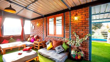 A cozy room with a brick wall, a wooden bench, and a table.