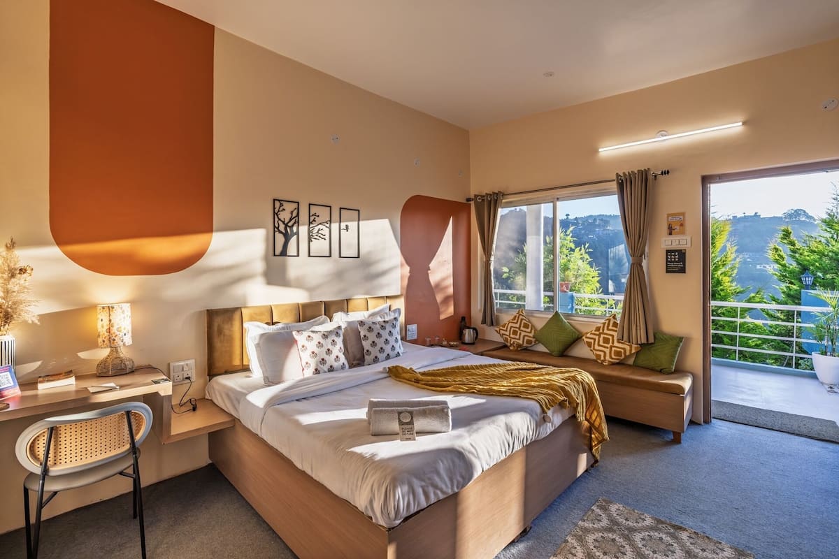 Ein modernes Hotelzimmer mit einem großen Bett, einem Schreibtisch und Blick ins Freie.