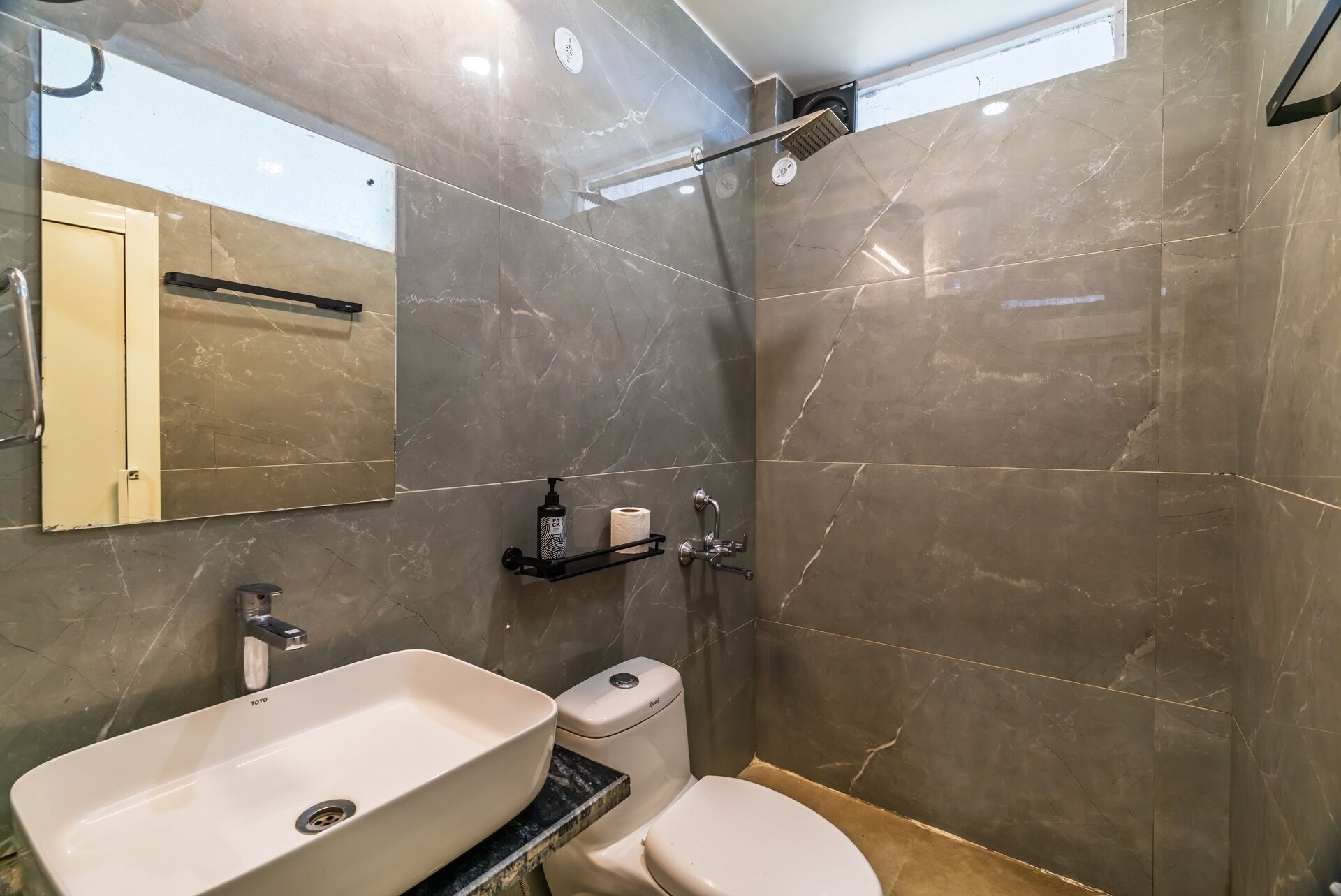 Un baño con lavamanos, inodoro y ducha blancos.