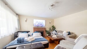 Una habitación de hotel moderna con una cama, un sofá, una mesa de centro y un televisor.