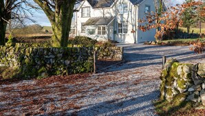 A white house with a stone wall and gravel driveway. - Craignair - a house that sleeps 4 guests in 2 bedrooms (Castle Douglas)