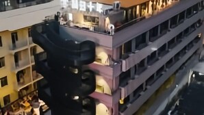 A multi-story building with a modern architectural design, featuring balconies and a mix of window styles.