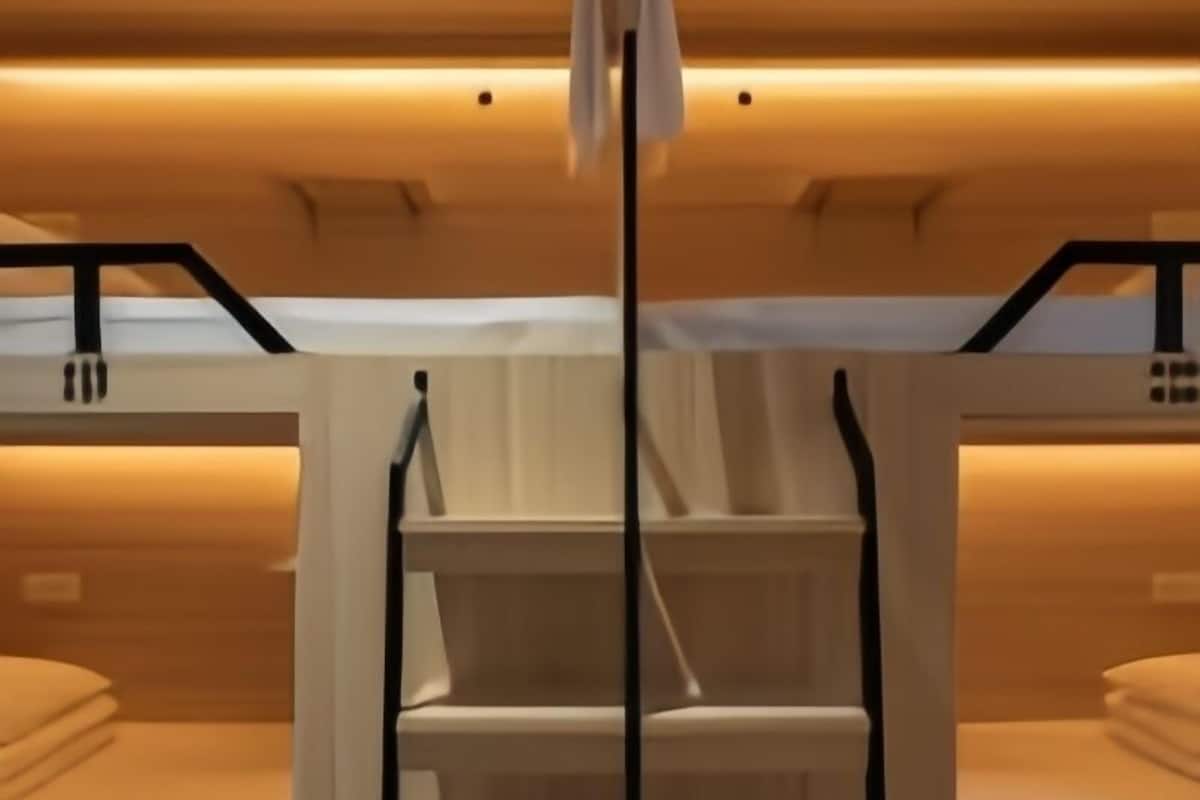 Een slaapkamer met stapelbed, houten plafond en een centrale draagbalk.