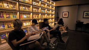 Un espace de lecture avec des étagères à livres et des personnes qui lisent.