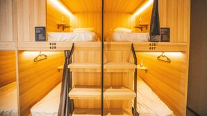 Une chambre d’hôtel avec deux lits, des murs en bois et un escalier central.