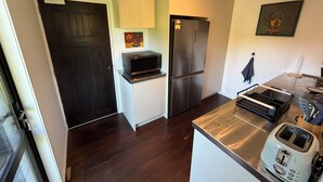 Una cocina compacta con microondas, refrigerador y tostadora.