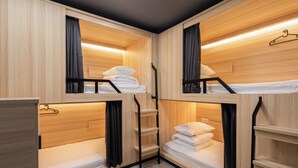 Habitación pequeña de estilo rústico con literas y estanterías empotradas.