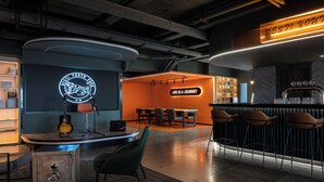 Een moderne bar met een neonbord, een gitaar en een bar.