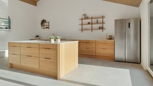 Eine moderne Küche mit Holzschnitzereien, einer zentralen Kochinsel und eingebauten Regalen.