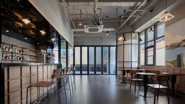 A modern bar area with a bar counter, stools, and hanging pendant lights. - Xiamen Desti Youth Park Hostel Zhongshan Road (Xiamen)