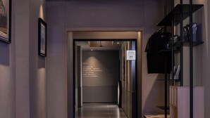 A modern hotel corridor with a wooden ceiling, recessed lighting, and a sign indicating a hotel room. - Xiamen Desti Youth Park Hostel Zhongshan Road (Xiamen)