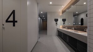 A modern bathroom with a tiled floor, a sink area with a mirror, and a door marked with the number 4. - Xiamen Desti Youth Park Hostel Zhongshan Road (Xiamen)