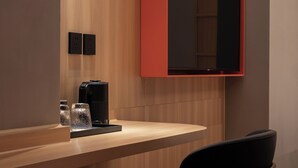 A modern kitchen with a wooden countertop, a black chair, and a red cabinet. - Xiamen Desti Youth Park Hostel Zhongshan Road (Xiamen)