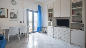 A modern living room with a dining area, a TV, and a bookshelf. - GuestHost - Cozy 45 sqm apartment, able to accommodate up to 4 people, located on the sixth floor of a modern building with lift.The property is located in an extremely strategic area, just 100 meters from Santa Maria Novella station, near the historic c (Florence)