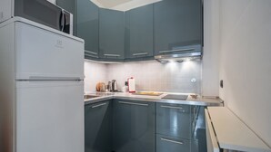 A compact kitchen with teal cabinets, a white refrigerator, and a tiled backsplash. - GuestHost - Cozy 45 sqm apartment, able to accommodate up to 4 people, located on the sixth floor of a modern building with lift.The property is located in an extremely strategic area, just 100 meters from Santa Maria Novella station, near the historic c (Florence)