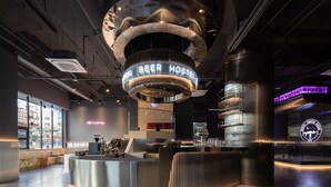 A modern bar area with a neon sign reading "PEER HOSTEL" and a circular metallic structure above it. - Hangzhou Desti Youth Park Hostel West Lake (Hangzhou)