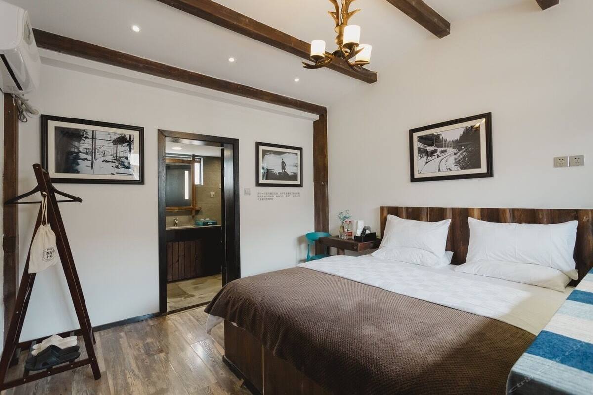 Ein Schlafzimmer mit einem großen Bett, einem Holzkopfende und drei gerahmten Bildern an der Wand.