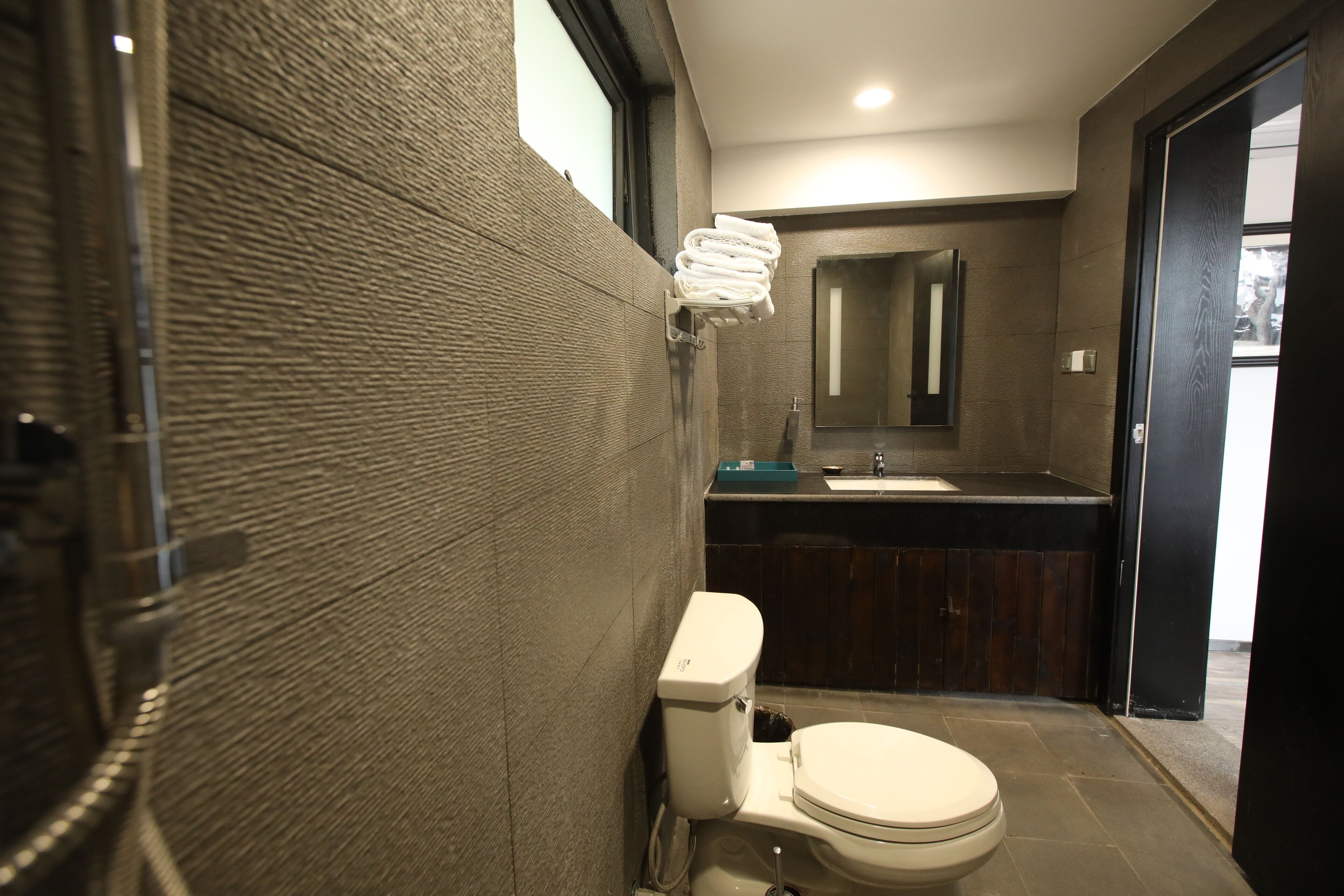 A modern bathroom with a toilet, a sink, and a mirror.