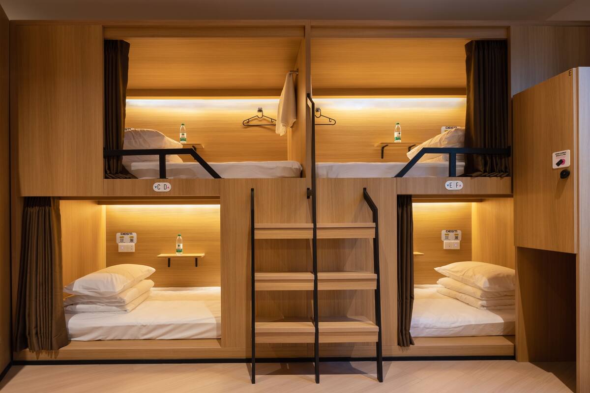 Quarto com beliches, paredes de madeira e escada central.