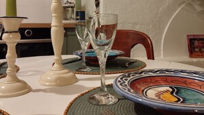 Une table à manger dressée avec de la verrerie, des assiettes et un chandelier.