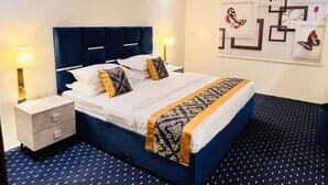 Ein Hotelzimmer mit einem großen Bett, zwei Nachttischen und einer Wand mit dekorativer Schmetterlingskunst.