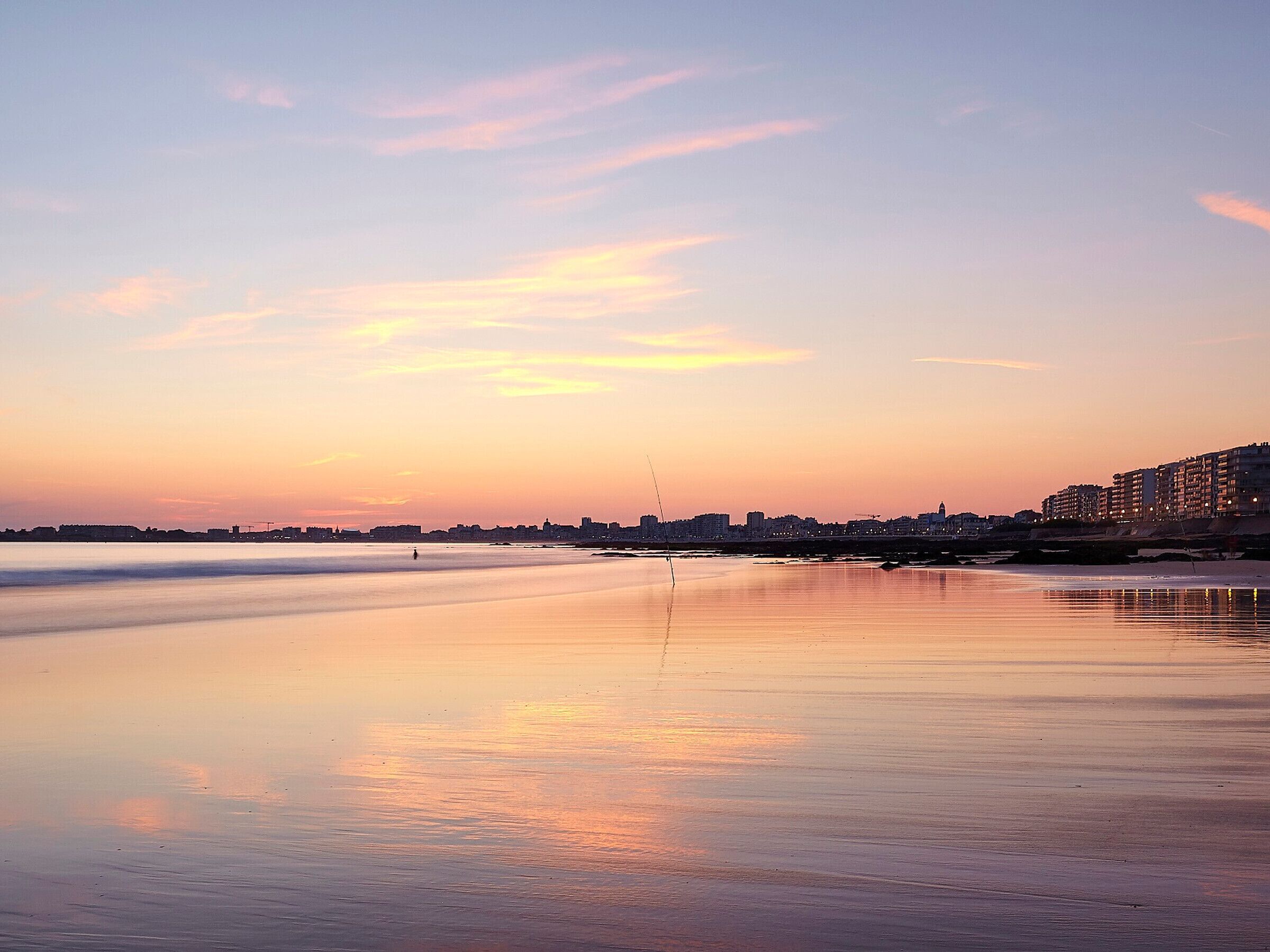 Een strand met een stadsachtergrond.