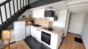 Una cocina compacta equipada con lavavajillas, horno y microondas.