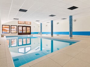 A swimming pool with clear water, surrounded by a tiled floor and walls. - Cozy apartment with large terrace at the foot of the slopes (Flumet)
