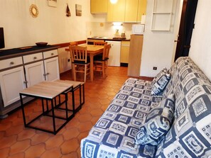 A compact living space with a sofa, a small dining table, and a kitchenette. - 2-room apartment with terrace and parking in Bormes-les-Mimosas (Bormes-les-Mimosas)