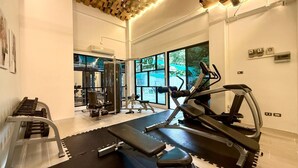 Una palestra con attrezzature per esercizi, tapis roulant e panche.